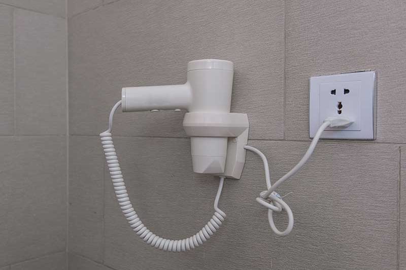 hair-dryer-hanging-on-wall-in-bathroom-PSTUZHL